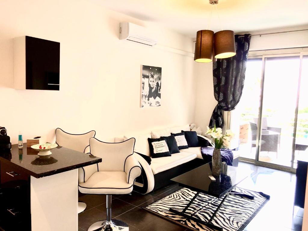 uma sala de estar com um sofá, uma mesa e cadeiras em Cannes la Croisette, Baoli 4 beds, balcony,parking em Cannes