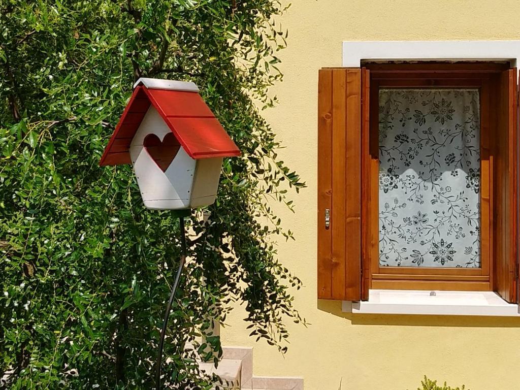 una casa de aves en el lateral de un edificio con ventana en Green Nest, en Farra di Soligo