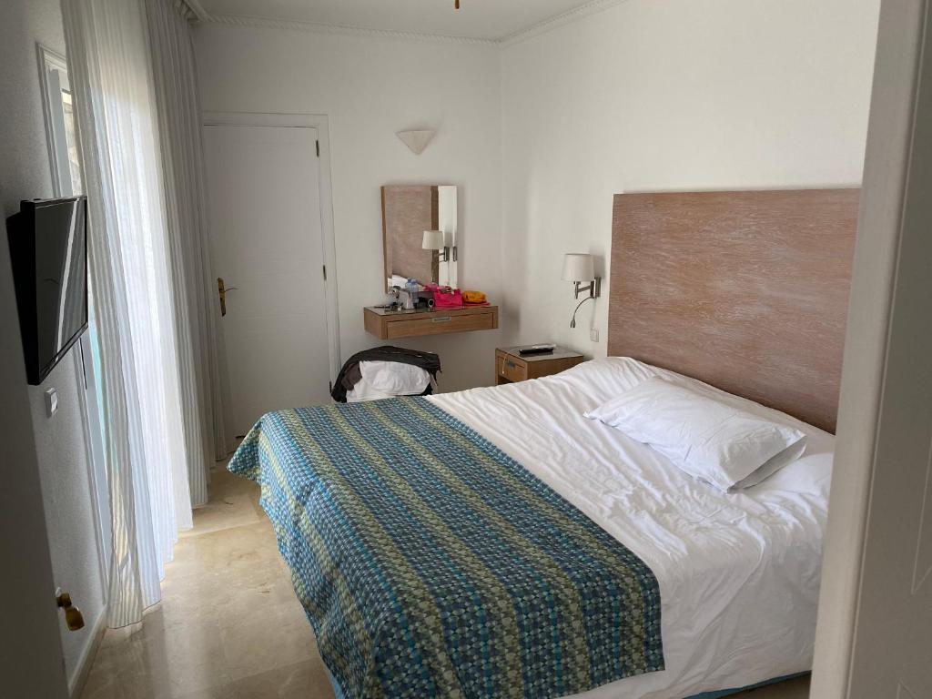 a bedroom with a bed with a blanket on it at Anfi Beach Club in Los Caideros