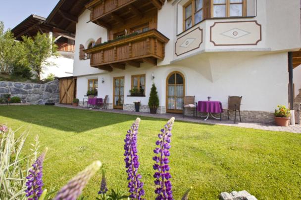 a large house with purple flowers in the yard at Apart Mangweth in Nauders