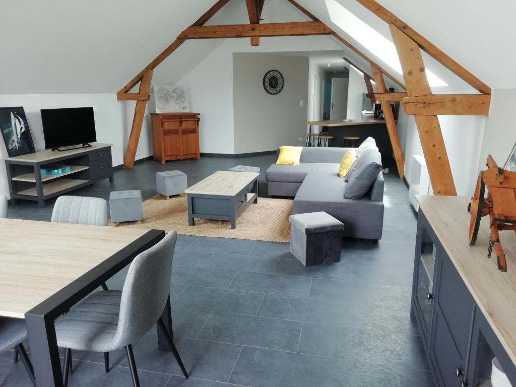 ein Wohnzimmer mit einem Sofa und einem Tisch in der Unterkunft La Voilerie in Fécamp