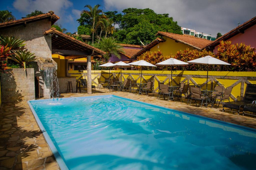 - une piscine en face d'une maison avec des chaises et des parasols dans l'établissement Pousada Lapônia, à Penedo