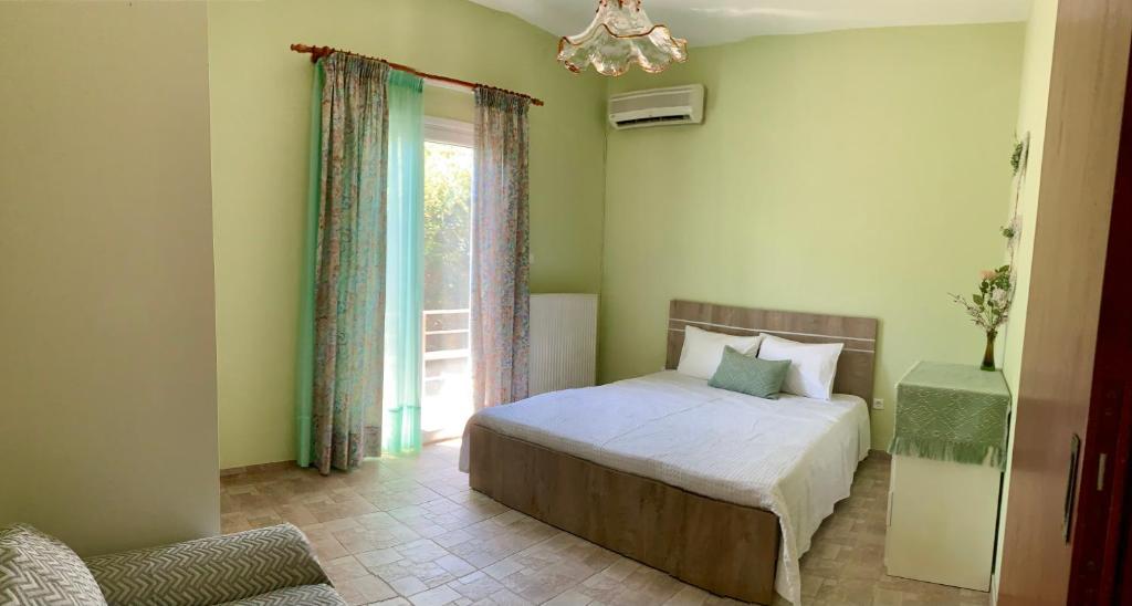 um quarto com uma cama e uma janela em Jo Relax House em Nea Makri