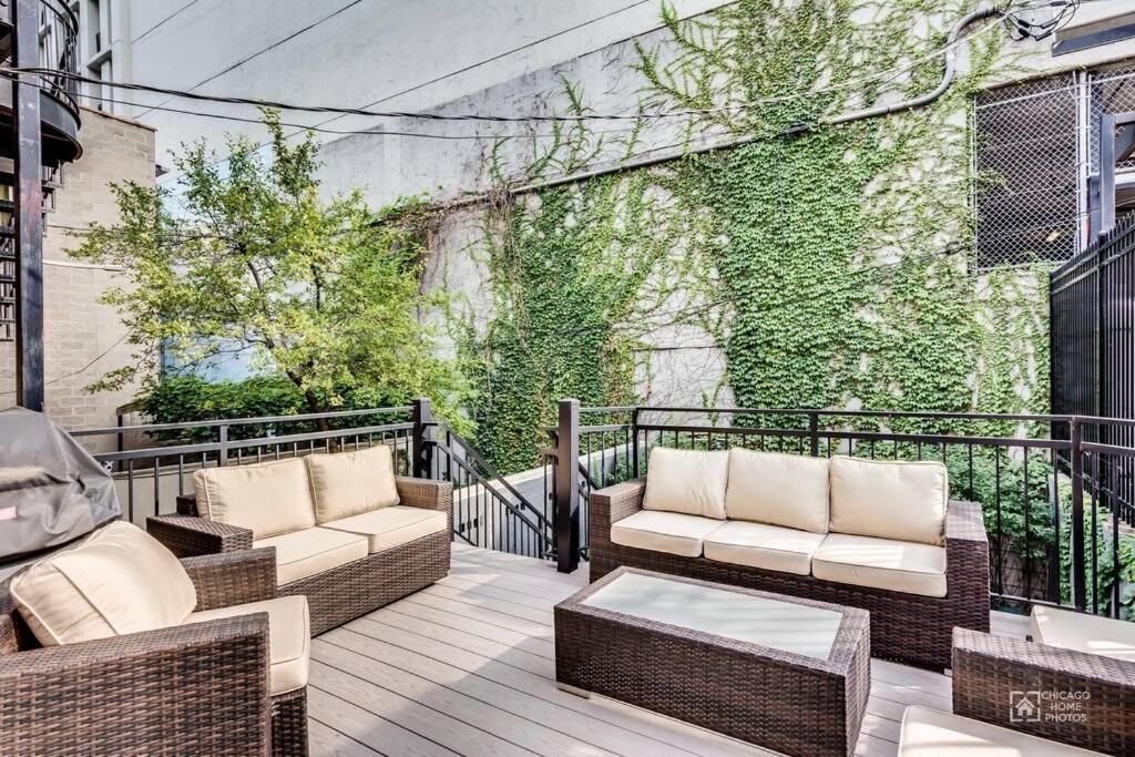 a balcony with wicker furniture and a green wall at Gold coast villa with free parking garage sleeps 10 in Chicago