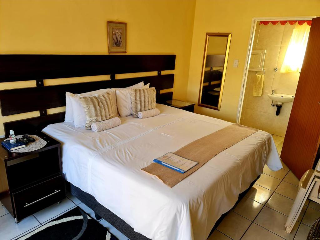 a bedroom with a large white bed in a room at Katlego guest house in Welkom