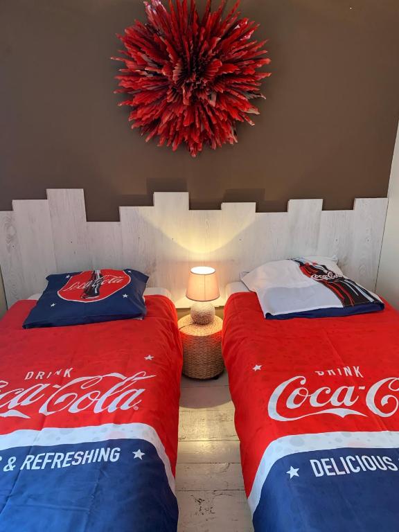 - une chambre avec 2 lits à coca cola et un lustre dans l'établissement La Canourguette, à La Canourgue