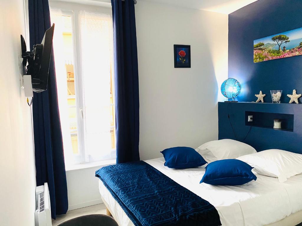 um quarto com uma cama com almofadas azuis e brancas em Studio MER gare part dieu em Lyon