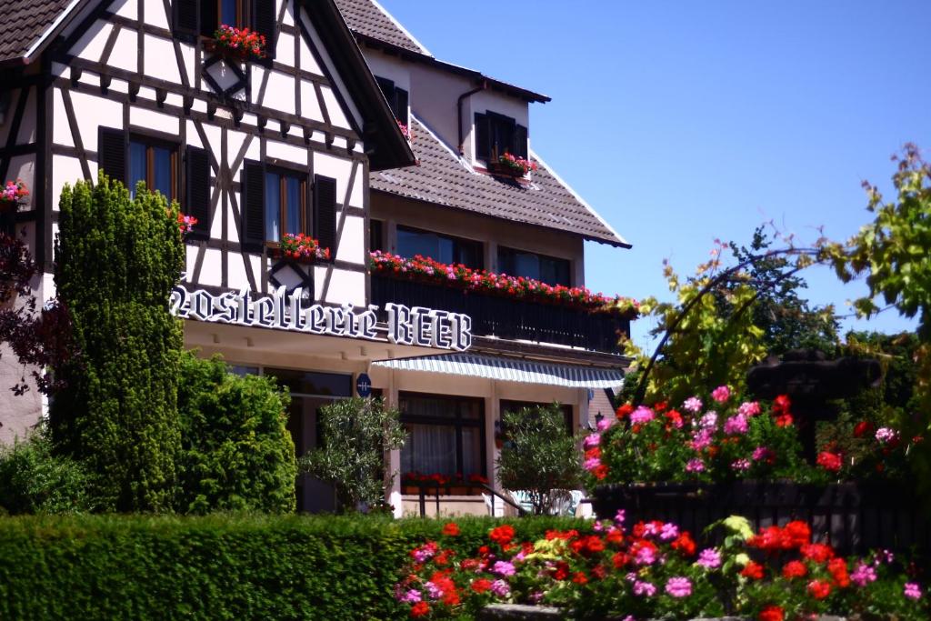 un bâtiment avec des fleurs devant lui dans l'établissement Hostellerie Reeb, à Marlenheim