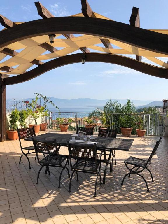 a patio with a table and chairs under an umbrella at Apartment Napitia Hills in Pizzo