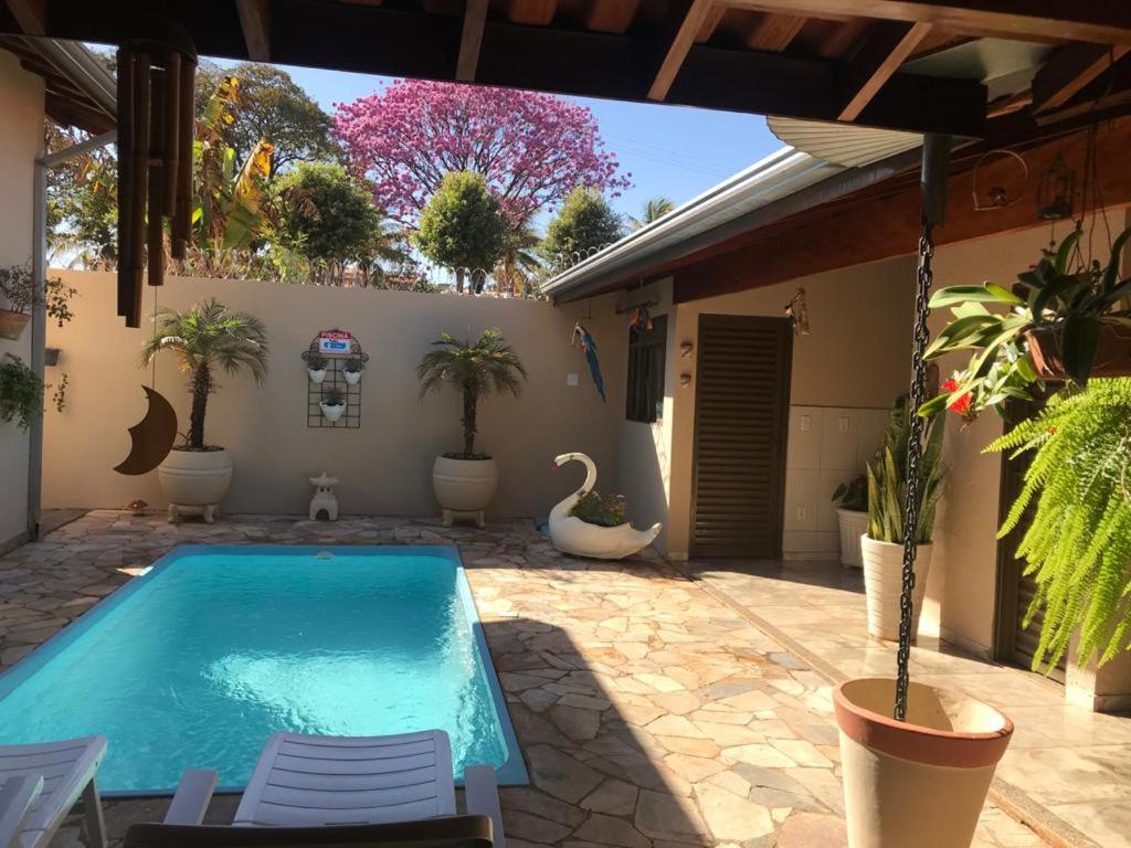 a swimming pool with a swan in a yard at CASA PRIMAVERA- À 2 km do Thermas dos Laranjais in Olímpia