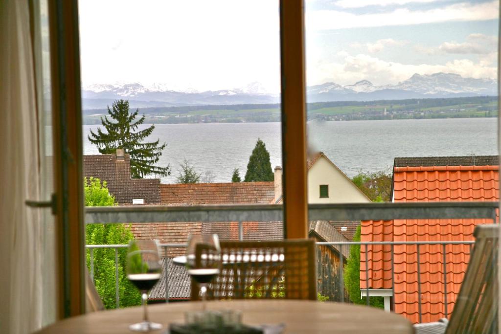 una ventana con mesa y vistas al agua en Ferienwohnung Schmid en Hagnau