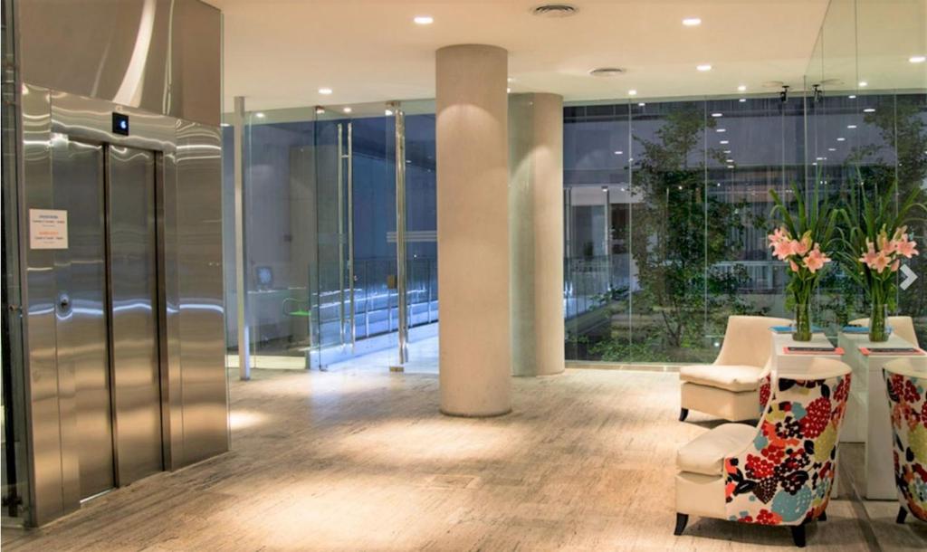 a lobby with chairs and a table in a building at Buenos Aires Loft in Buenos Aires