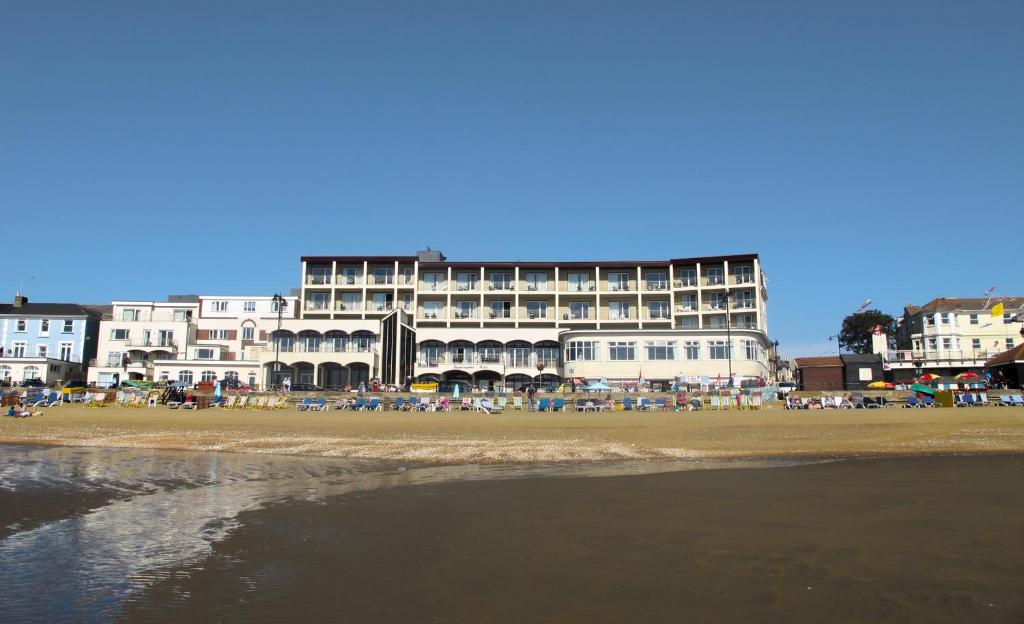 a large building on a beach with the ocean at Sandringham Hotel - Seafront, Sandown --- Car Ferry Optional Extra 92 pounds Return from Southampton in Sandown