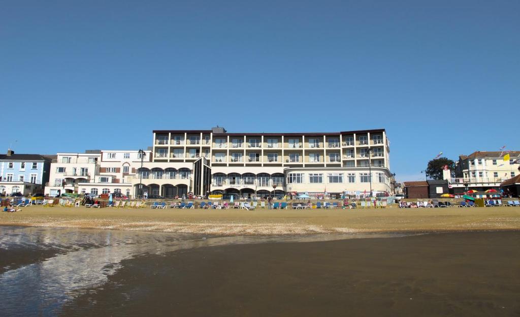 un gran edificio en una playa con el océano en Sandringham Hotel - Seafront, Sandown --- Car Ferry Optional Extra 92 pounds Return from Southampton, en Sandown