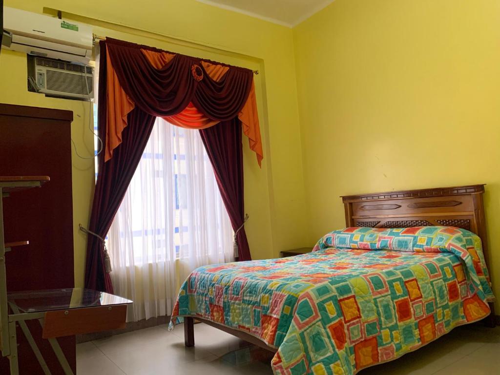 1 dormitorio con cama y ventana en Hotel Élite Internacional, en Guayaquil