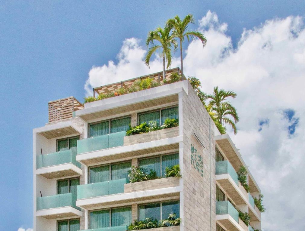 un edificio con palmeras encima en Newport House Playa Boutique Hotel, en Playa del Carmen