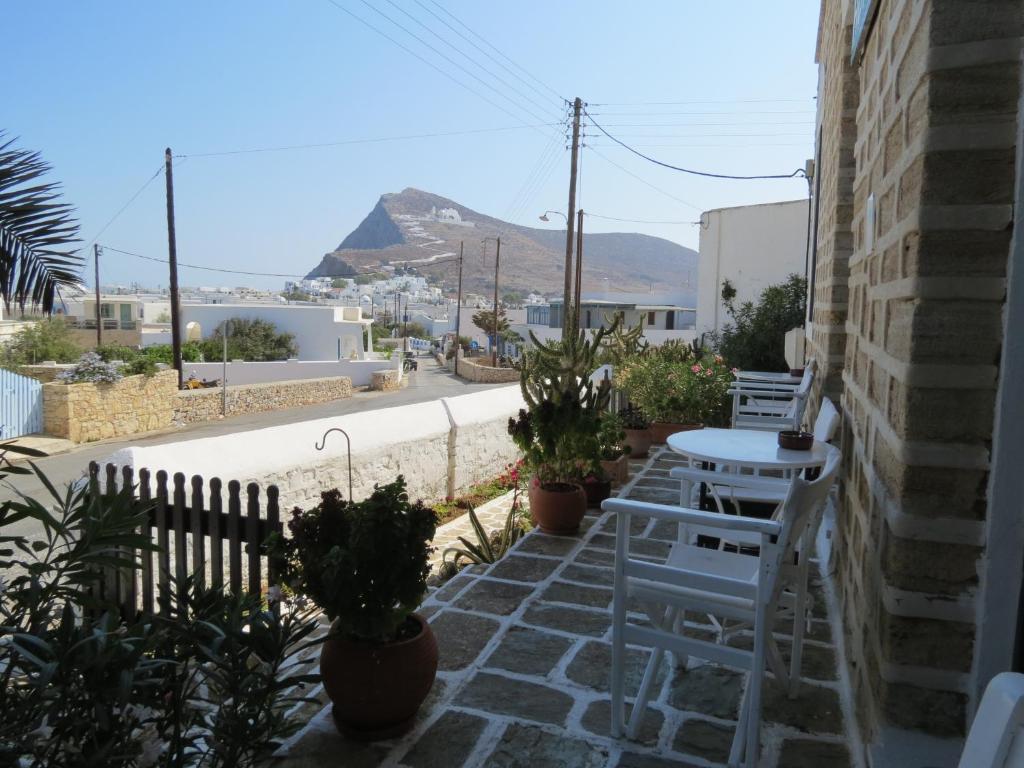 a patio with chairs and tables and a view of a city at Fanivevisgarden in Chora Folegandros
