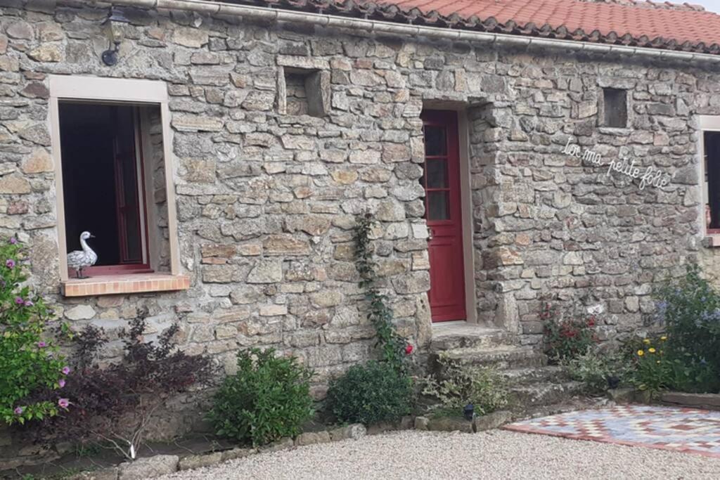 a stone house with a bird sitting in a window at Gite de la petite folie in Aizenay