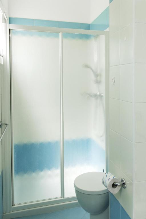 W łazience znajduje się toaleta i przeszklony prysznic. w obiekcie Hotel Merano w Grado
