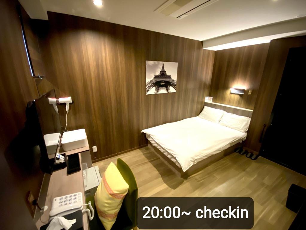 Petit Hotel mio في سايتاما: غرفه صغيره فيها سرير وكاميرا
