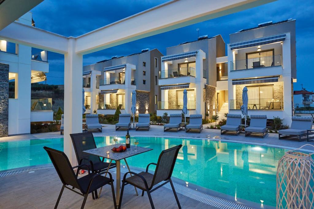a villa with a swimming pool at night at GreyStone Suites in Paralia Dionysiou