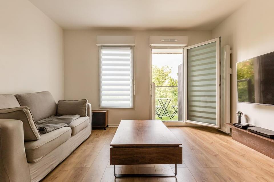 a living room with a couch and a coffee table at Superbe Studio à 2 Stations de Paris Centre 15min à pied du Stade de France in Saint-Denis