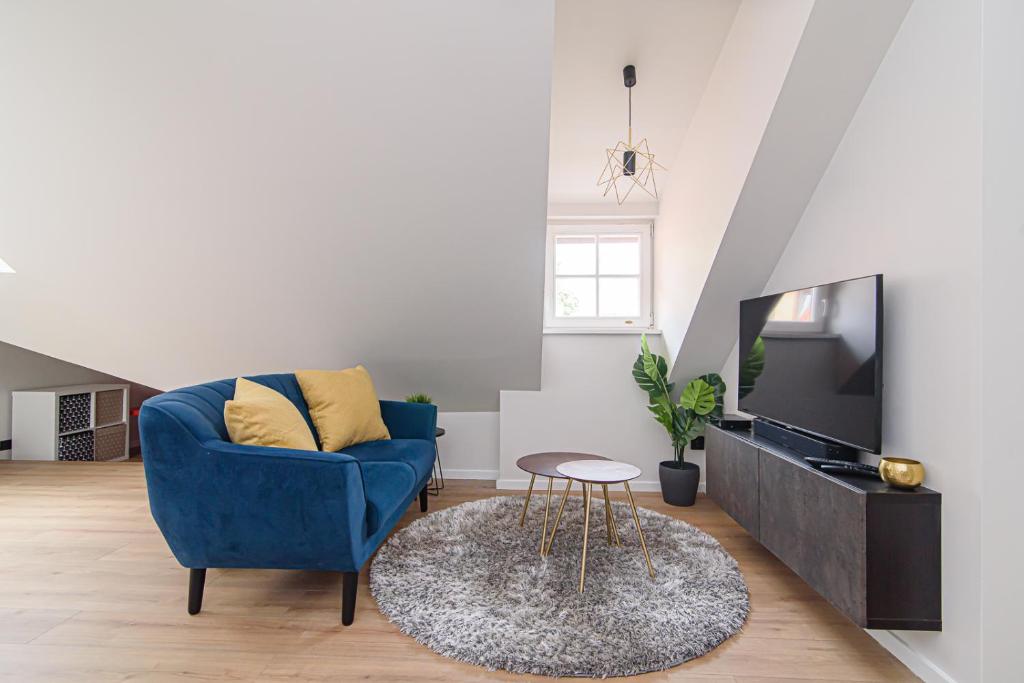 salon z niebieskim krzesłem i telewizorem w obiekcie Zydu str two bedrooms Apartment by URBAN RENT w Wilnie