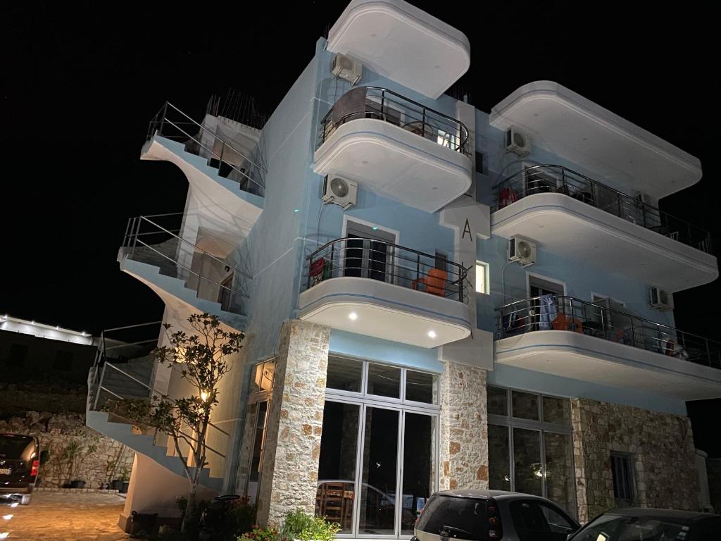 a large white building with balconies at night at Vila Llaka in Himare