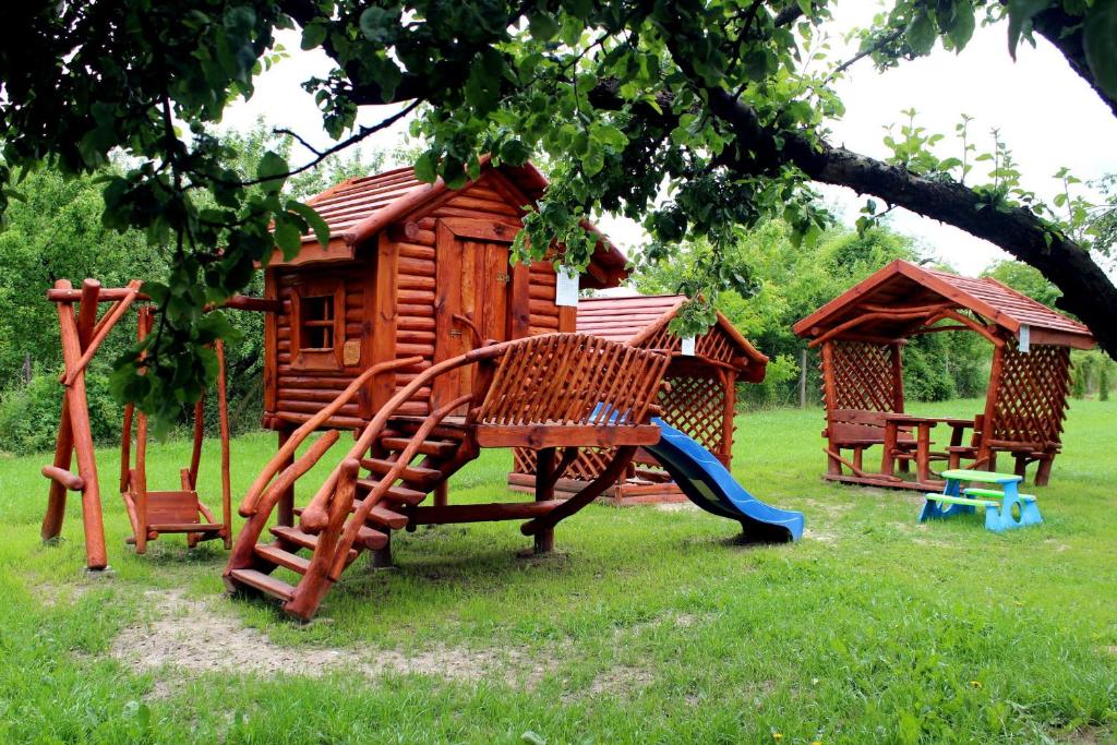 un parque infantil frente a una cabaña de madera en Willa-Restauracja Victoria en Ostrowiec Świętokrzyski