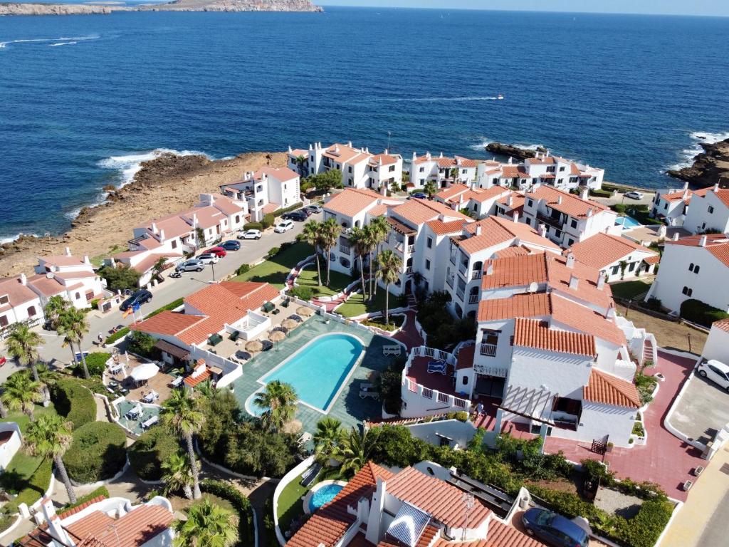 una vista aérea de un complejo y del océano en Apartamentos El Bergantin Menorca Club en Fornells