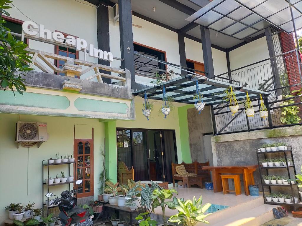 a building with a balcony with plants and a table at Cheap Inn Banyuwangi in Banyuwangi