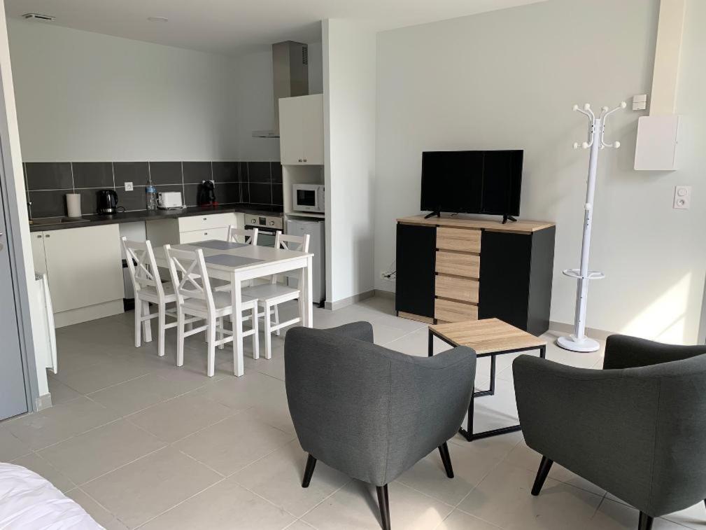 a living room with a kitchen and a table and chairs at Studio Saint-Léger in Soligny-les-Étangs