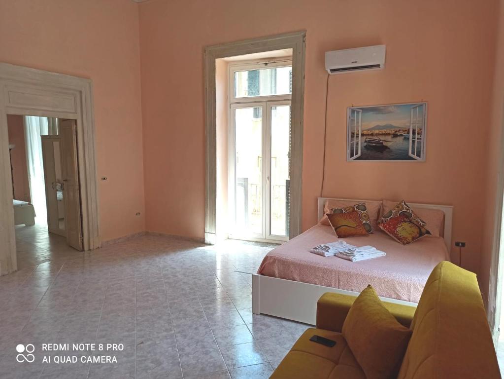 um quarto com uma cama e um sofá num quarto em Il cantuccio di Diana em Nápoles