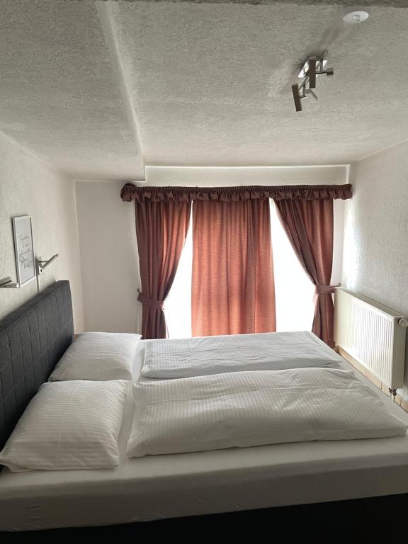 a bedroom with a large bed with a window at Hotel Restaurant Germania in Neuwied