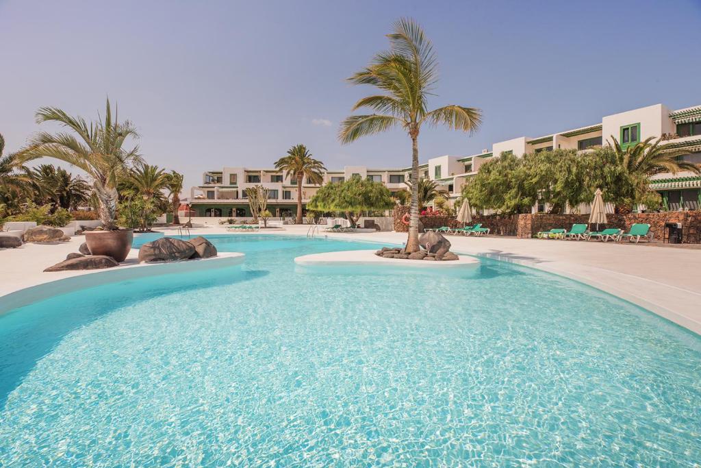 a swimming pool in the middle of a resort at Lanzahost Cucharas Dreams in Costa Teguise