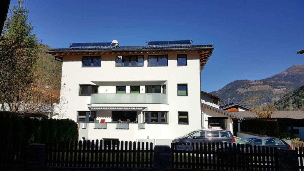 un edificio blanco con coches estacionados frente a él en Appartement Spiss, en Ried im Oberinntal