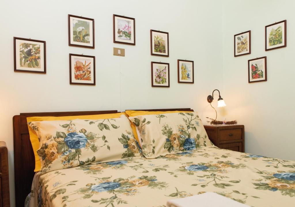sypialnia z łóżkiem i oprawionymi obrazami na ścianie w obiekcie Il Sorgituro - Agriturismo w mieście Postiglione
