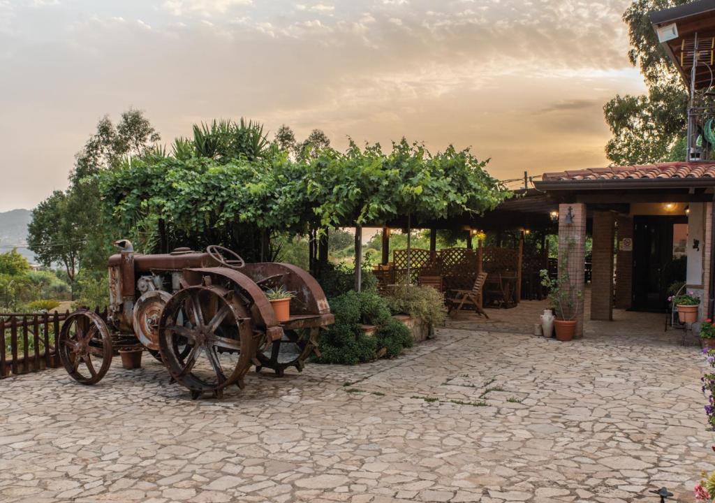 Stary traktor siedzi na kamiennym patio. w obiekcie Il Sorgituro - Agriturismo w mieście Postiglione