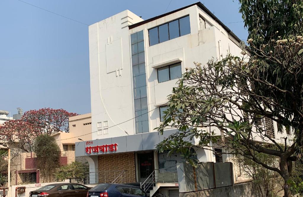 een gebouw in een straat met auto's aan de voorkant bij Hotel Rajwada Aurangabad in Aurangabad