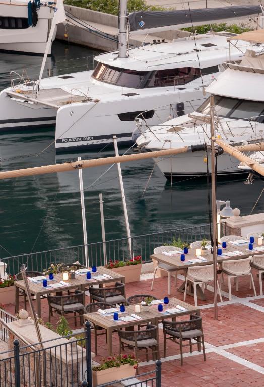a group of tables and chairs on a dock with boats at Radisson Collection Hotel, Bodrum in Akyarlar
