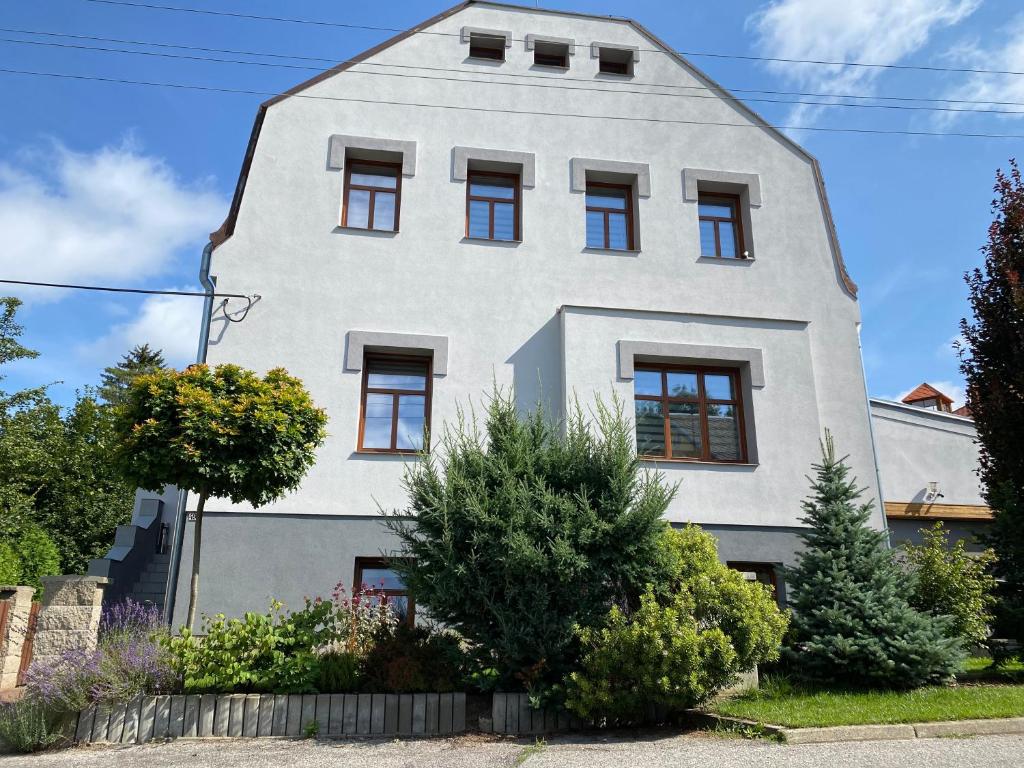 a white house with a gambrel roof at Rodinný apartmán v ulici Údolní 493 Rychnov u Jablonce nad Nisou in Pelíkovice