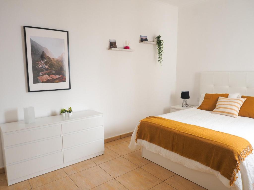 biała sypialnia z łóżkiem i białą komodą w obiekcie Apartamento Horizonte El Puertito de Güímar w mieście Puertito de Güímar
