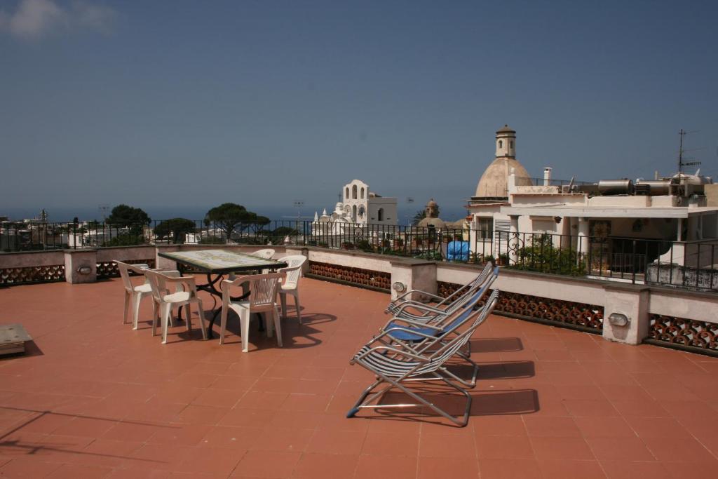 un patio con mesa y sillas en la azotea en Casa della Conchiglia - Capri, en Anacapri