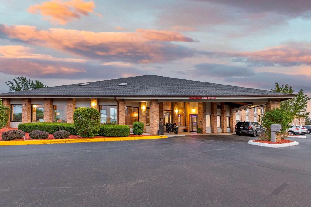 un hôtel situé à l'avant d'un immeuble avec un parking dans l'établissement Rodeway Inn Coopersville, à Coopersville