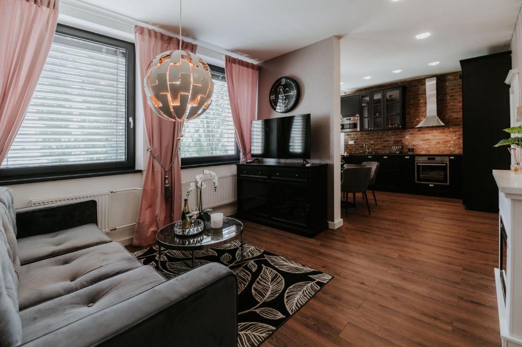 a living room with a couch and a table and a kitchen at Apartmány Evia clinic in Levice