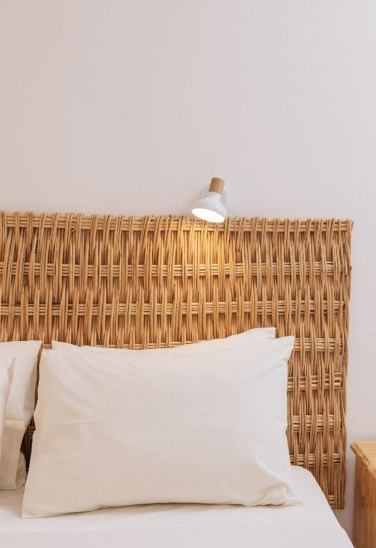 a bed with a wicker headboard in a bedroom at Amalia in Matala