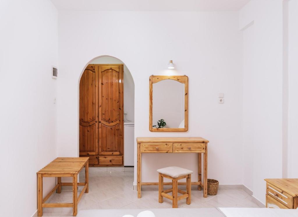 a room with a mirror and a wooden table and stool at Amalia in Matala