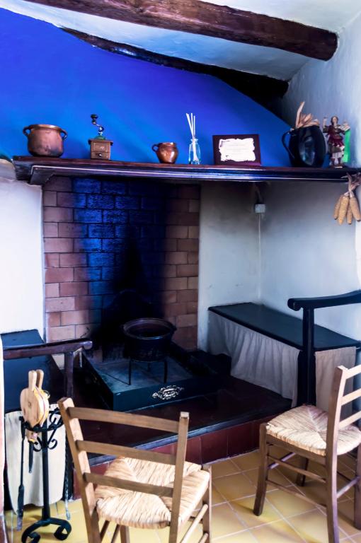 a living room with a brick fireplace with two chairs at Casa Rural Los Lilos in Gotor