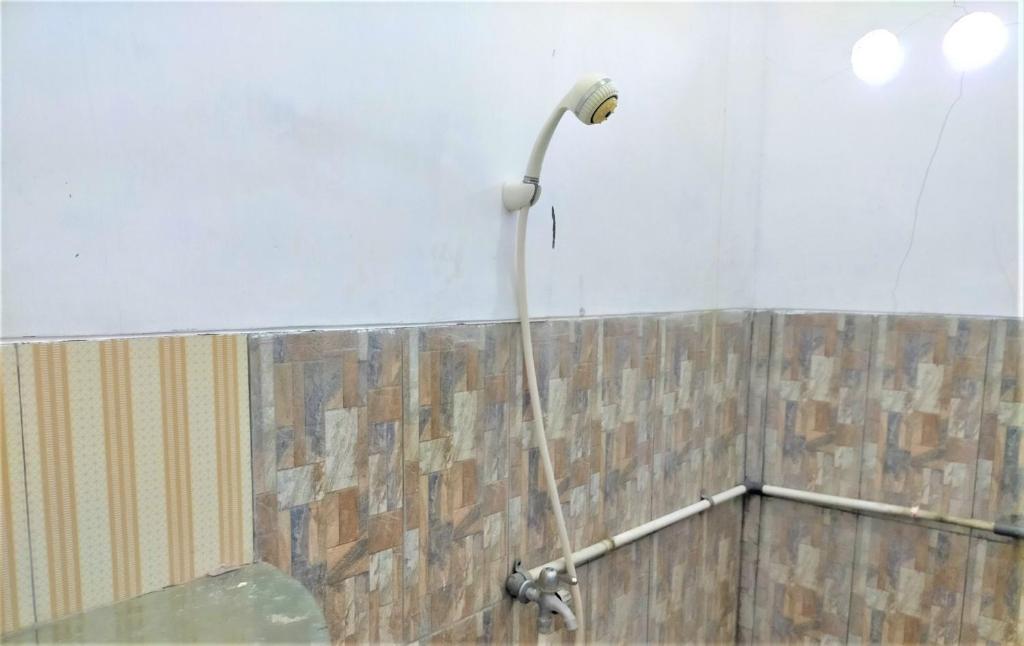 una doccia con tubo fissato a un muro di Kendang Kempul Hostel a Dadapan