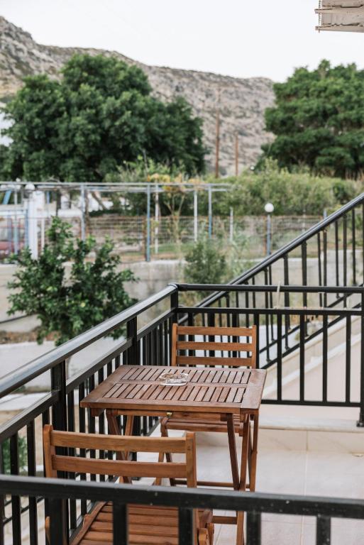 a wooden table and benches on a balcony at Amalia in Matala